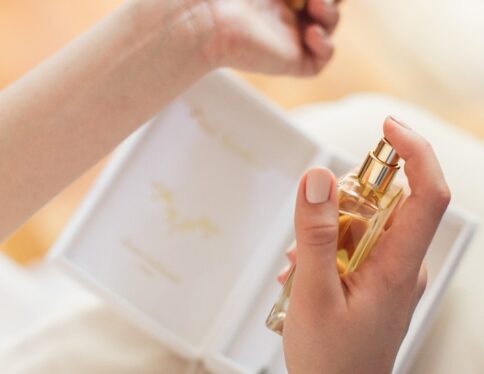 Mariée en train de se parfumer le poignet avec un parfum Galimard au flacon doré